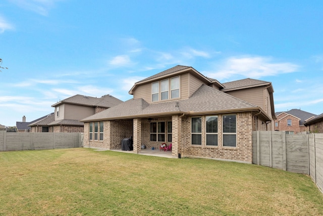 rear view of property featuring a patio and a yard