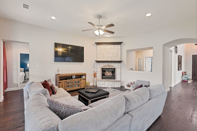 living room with ceiling fan, dark hardwood / wood-style floors, and a fireplace