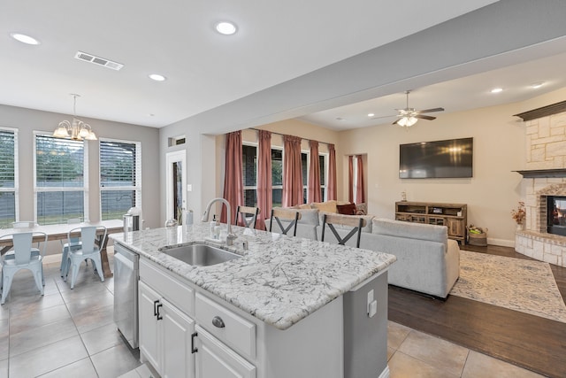 kitchen featuring white cabinetry, sink, a healthy amount of sunlight, and decorative light fixtures