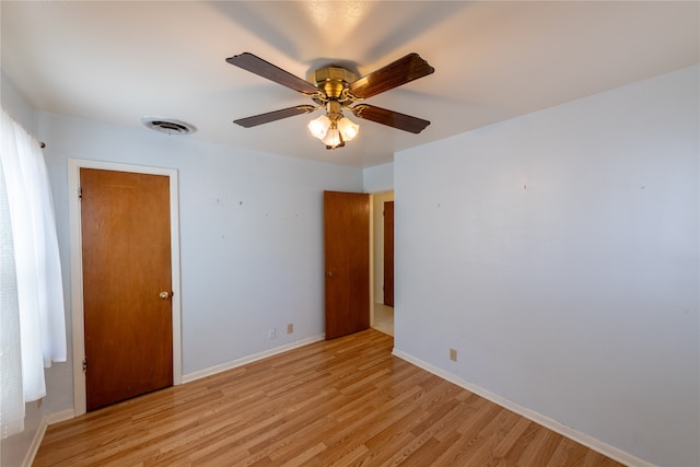 empty room with ceiling fan and light hardwood / wood-style flooring