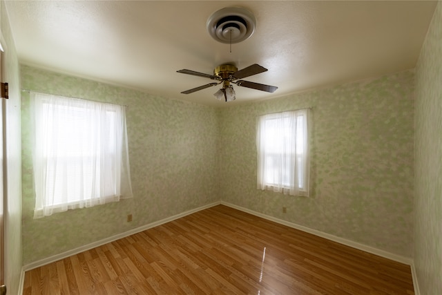 unfurnished room with ceiling fan and hardwood / wood-style flooring