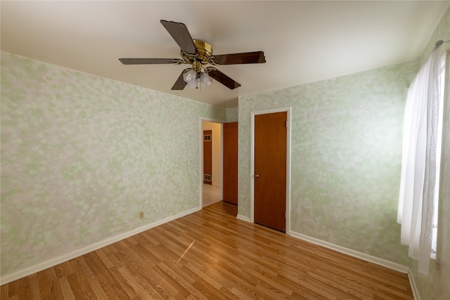 spare room with light wood-type flooring and ceiling fan