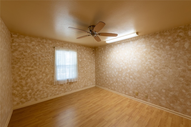 unfurnished room with ceiling fan, a textured ceiling, and hardwood / wood-style floors