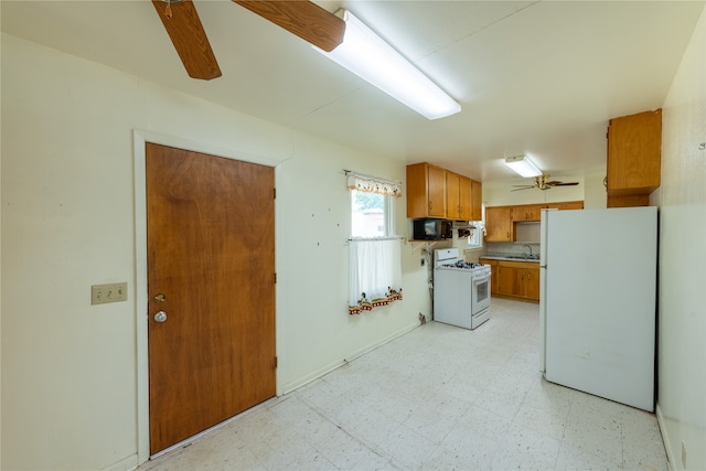 kitchen with white appliances, ceiling fan, and sink