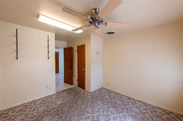 spare room featuring light carpet and ceiling fan