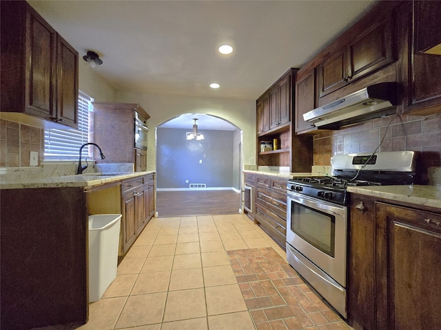 kitchen featuring sink, dark brown cabinetry, stainless steel appliances, and light tile patterned floors