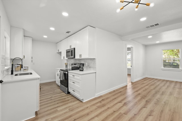 kitchen featuring white cabinetry, appliances with stainless steel finishes, sink, and light hardwood / wood-style flooring