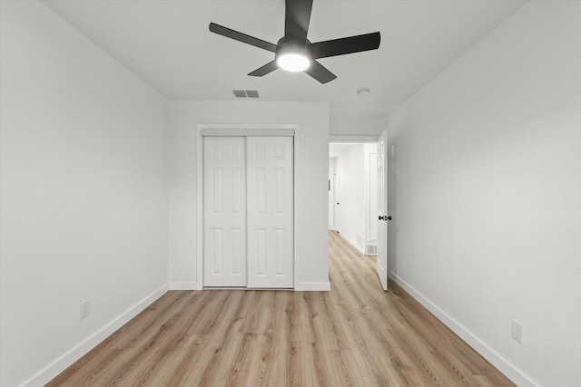 unfurnished bedroom with ceiling fan, a closet, and light hardwood / wood-style flooring