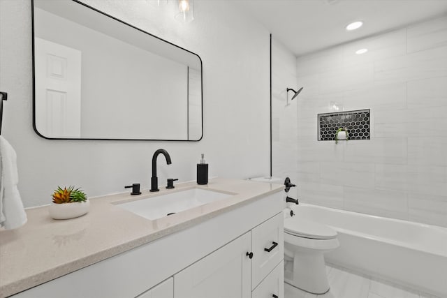 full bathroom featuring toilet, tiled shower / bath combo, and vanity