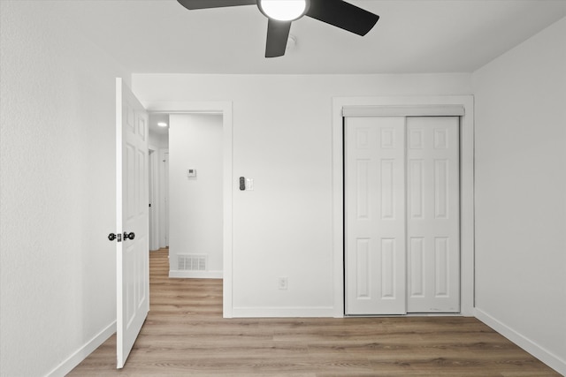 unfurnished bedroom featuring light wood-type flooring, ceiling fan, and a closet