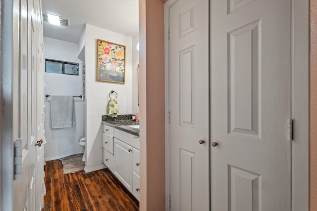 bathroom featuring vanity, wood-type flooring, and toilet