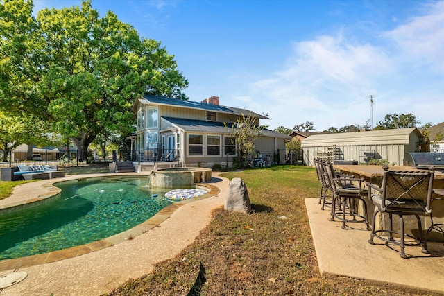 back of house featuring a patio, a pool with hot tub, and a lawn