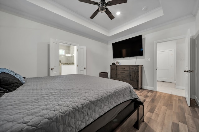 bedroom with ornamental molding, a tray ceiling, light wood-type flooring, and ceiling fan