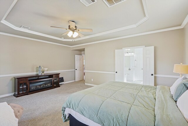 bedroom featuring ceiling fan, a raised ceiling, ornamental molding, and light carpet