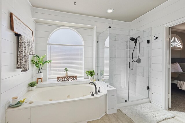 bathroom with hardwood / wood-style flooring, a wealth of natural light, and shower with separate bathtub