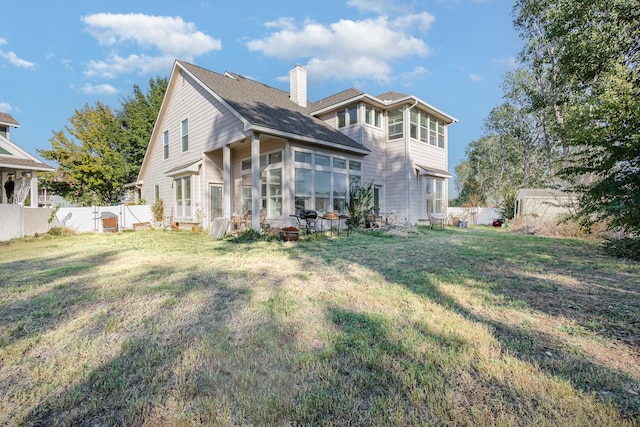 view of front of house with a sunroom and a front yard