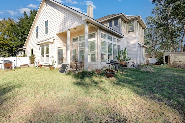 rear view of house featuring a yard and a sunroom