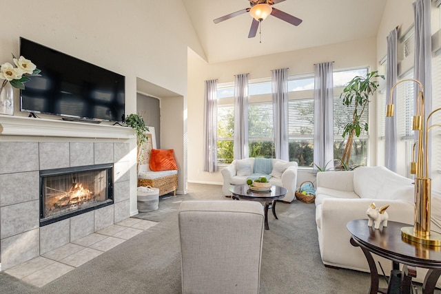 carpeted living room featuring ceiling fan, vaulted ceiling, and a tile fireplace