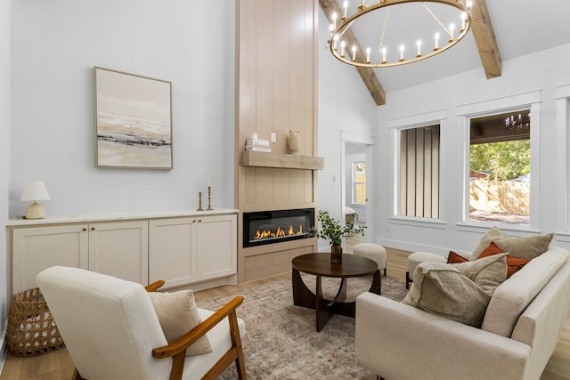 living room featuring high vaulted ceiling, light hardwood / wood-style flooring, beamed ceiling, and a notable chandelier