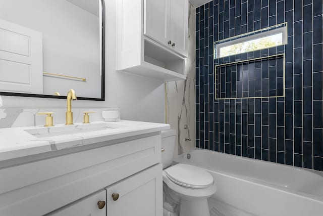 full bathroom with vanity, tiled shower / bath combo, and toilet