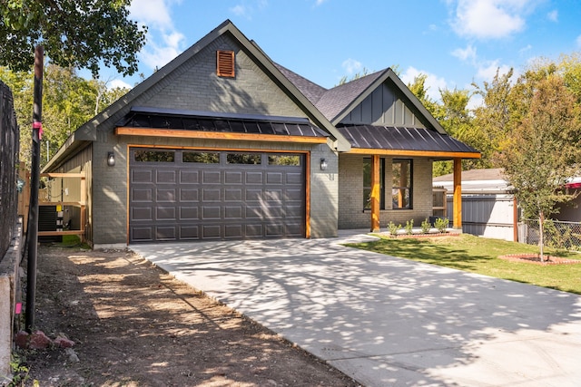 view of front of home with a garage and central air condition unit