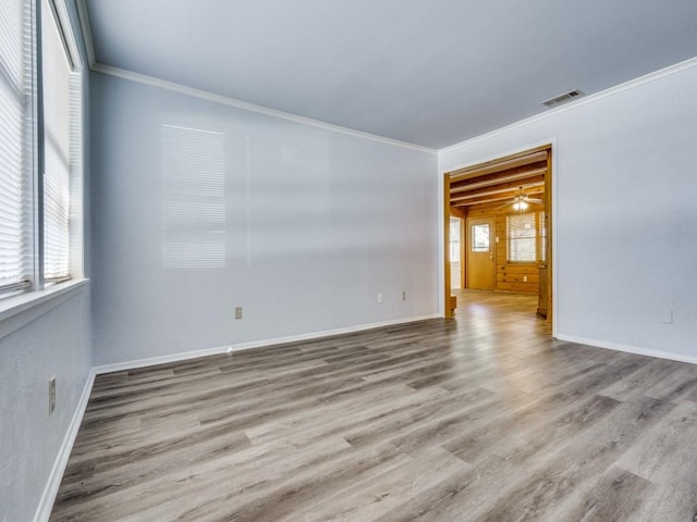 empty room featuring light hardwood / wood-style floors and crown molding