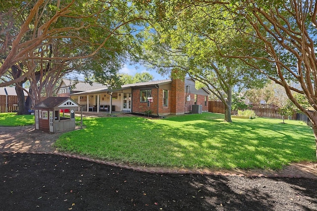 rear view of house with a yard and central AC unit