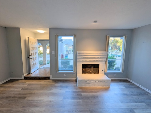 unfurnished living room featuring wood-type flooring and plenty of natural light