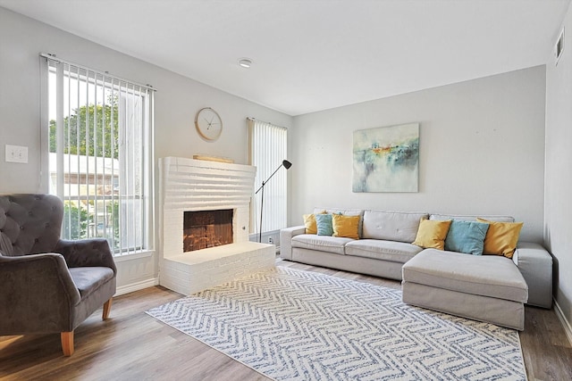 living room featuring hardwood / wood-style flooring, plenty of natural light, and a fireplace