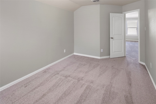 carpeted spare room with lofted ceiling