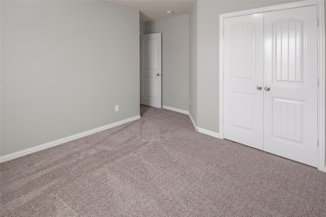 unfurnished bedroom featuring a closet and light colored carpet