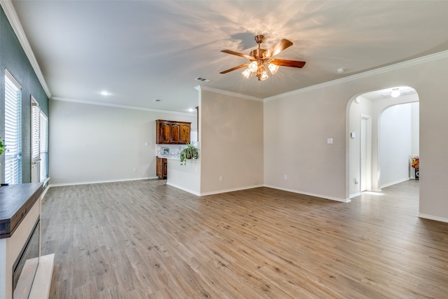 unfurnished living room featuring ornamental molding, light wood-type flooring, and ceiling fan