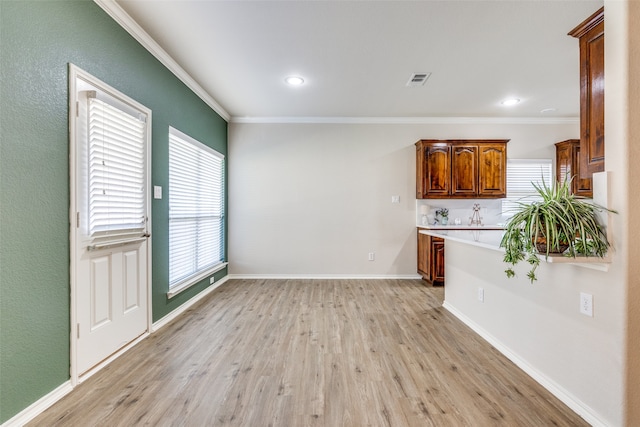 kitchen featuring crown molding and light hardwood / wood-style floors