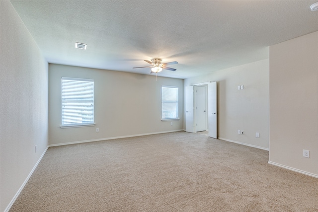 carpeted empty room featuring ceiling fan and a textured ceiling