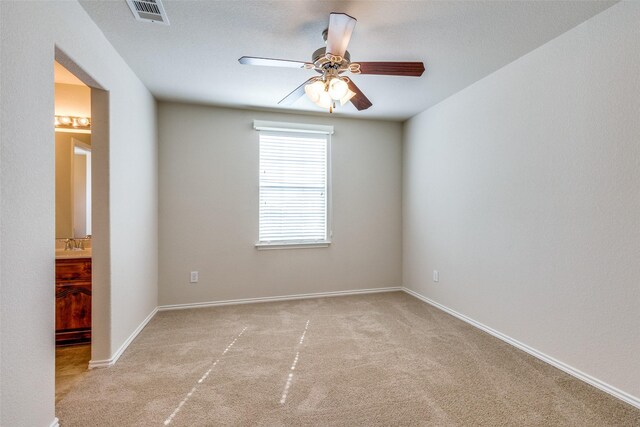 empty room featuring ceiling fan and light colored carpet