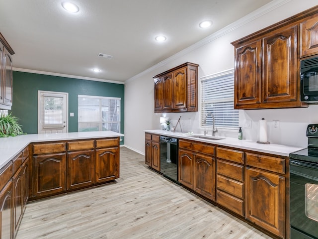 kitchen featuring light hardwood / wood-style flooring, kitchen peninsula, ornamental molding, sink, and black appliances