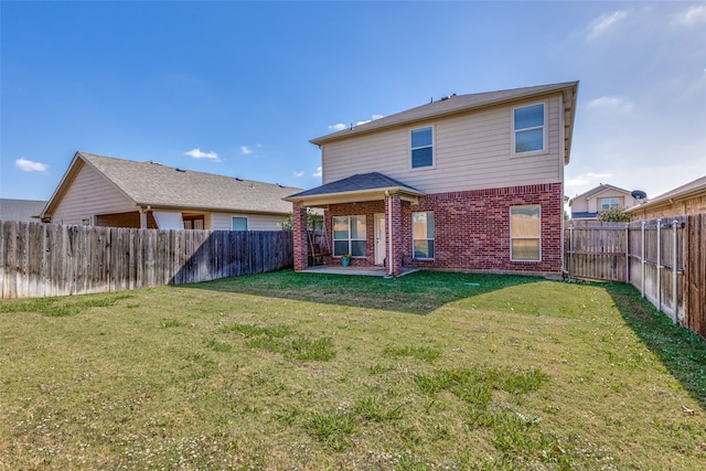 rear view of property with a patio and a lawn