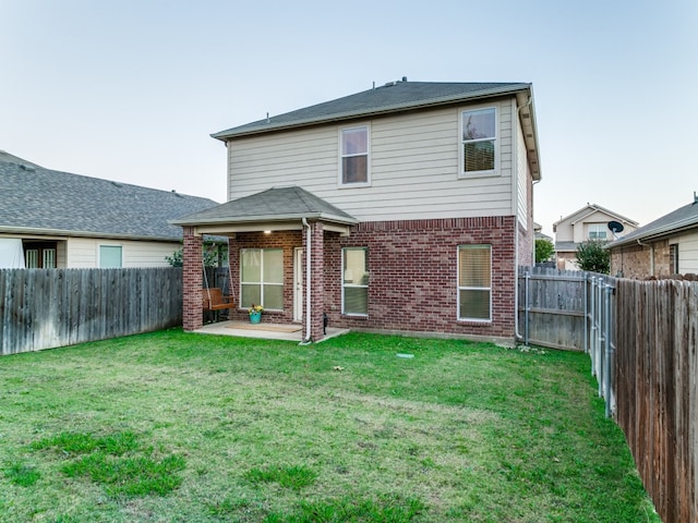 rear view of property with a patio and a lawn