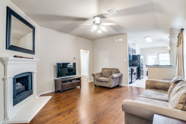 living room featuring ceiling fan and dark hardwood / wood-style flooring