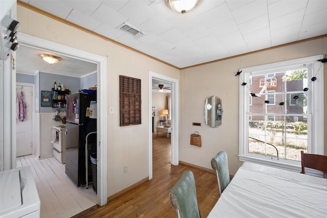 dining room with light hardwood / wood-style floors, crown molding, washer / clothes dryer, and ceiling fan