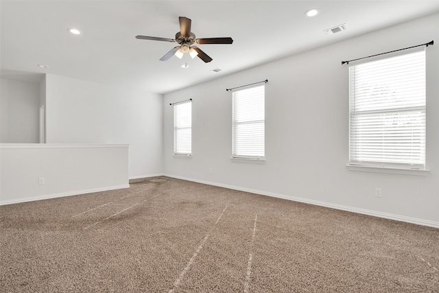 empty room featuring ceiling fan and carpet