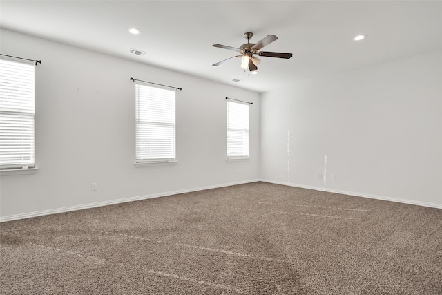 carpeted spare room with ceiling fan