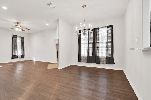 empty room featuring dark hardwood / wood-style flooring and ceiling fan with notable chandelier