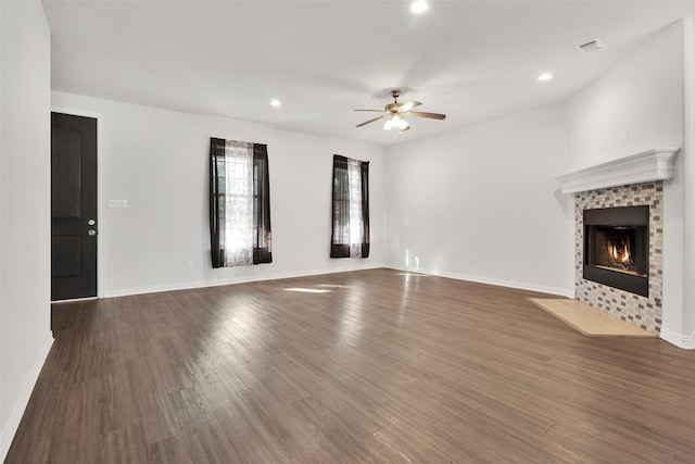 unfurnished living room featuring ceiling fan, dark wood-type flooring, and a fireplace