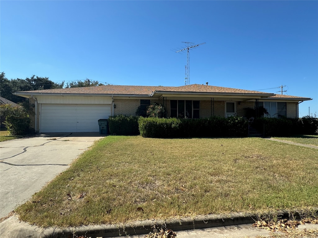 ranch-style home with a garage and a front lawn