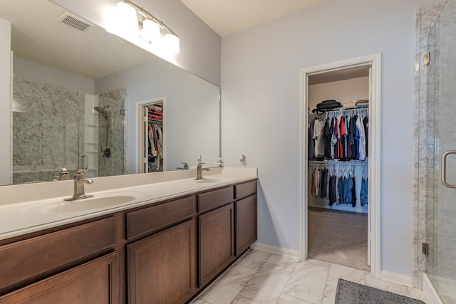 bathroom featuring a shower with door and vanity