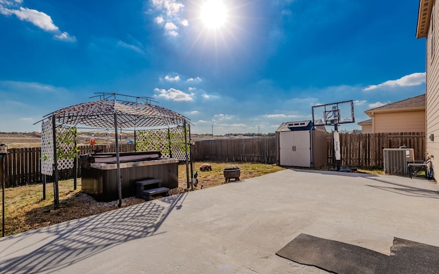 view of patio featuring a gazebo, a hot tub, a shed, and central AC unit