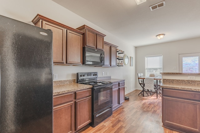 kitchen featuring black appliances and light wood-type flooring