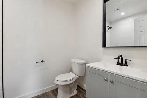 bathroom featuring vanity, hardwood / wood-style floors, and toilet