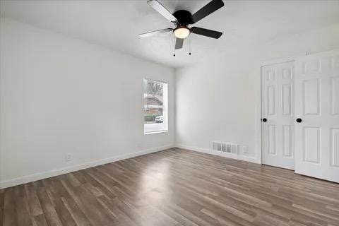 spare room with ceiling fan and dark hardwood / wood-style floors